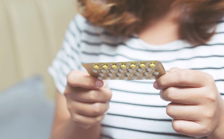 Woman holding a pack of tablets