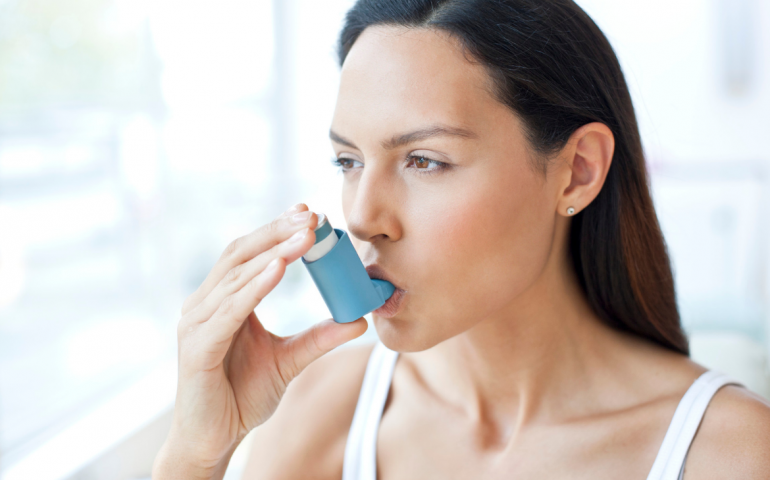 Woman using her inhaler